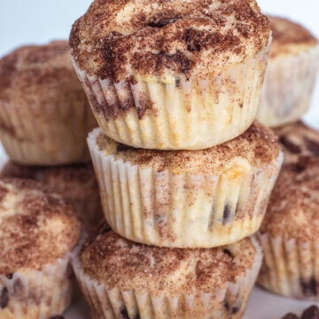 stack of eggless chocolate chip muffins on a plate with few chocolate chips on side