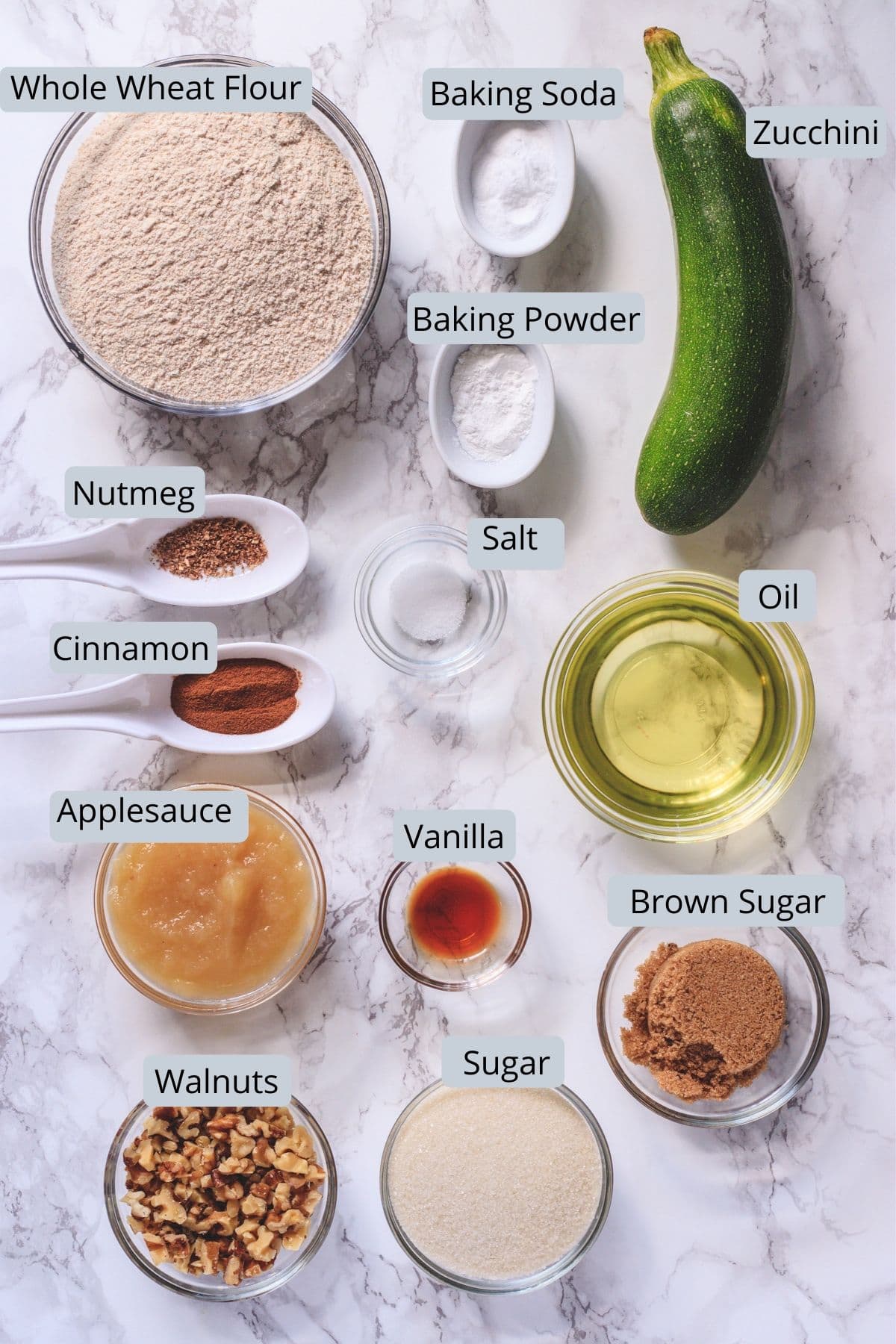 Eggless zucchini bread ingredients in individual bowls with labels.