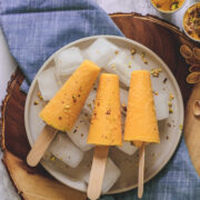 3 Mango Kulfi on ice cubes full of plate & napkin under it