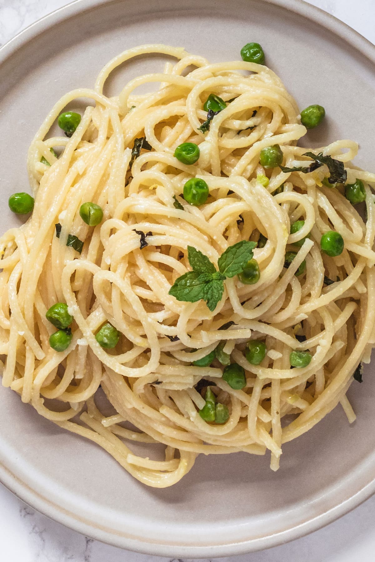 Top, close up view of peas, ricotta pasta in a plate