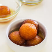 milk powder gulab jamun in a bowl with 2 bowls in the back