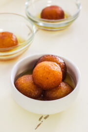 milk powder gulab jamun in a bowl with 2 bowls in the back