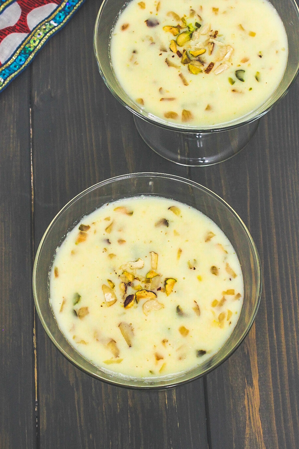 Top view of basundi in two serving bowls with garnish of chopped nuts