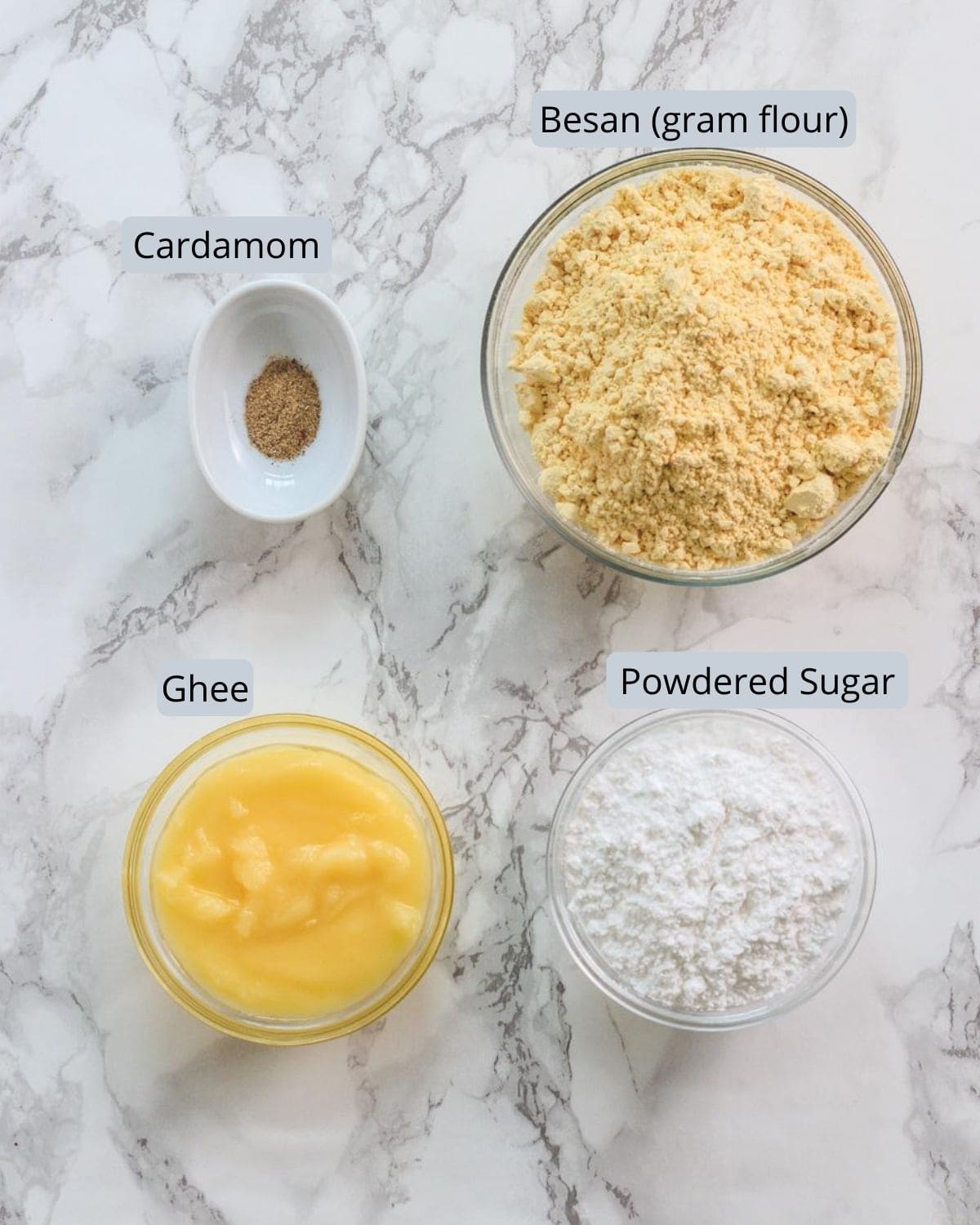 Image of ingredients used in besan ladoo recipe. Includes besan, sugar, cardamom, ghee.