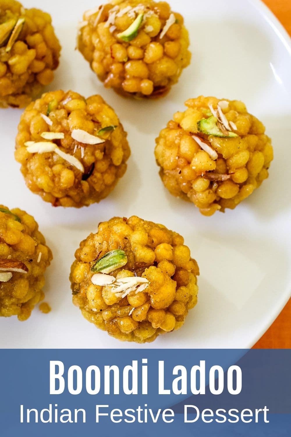 Boondi ladoo on plate garnished with chopped nuts with text at the bottom of the image for pinterest