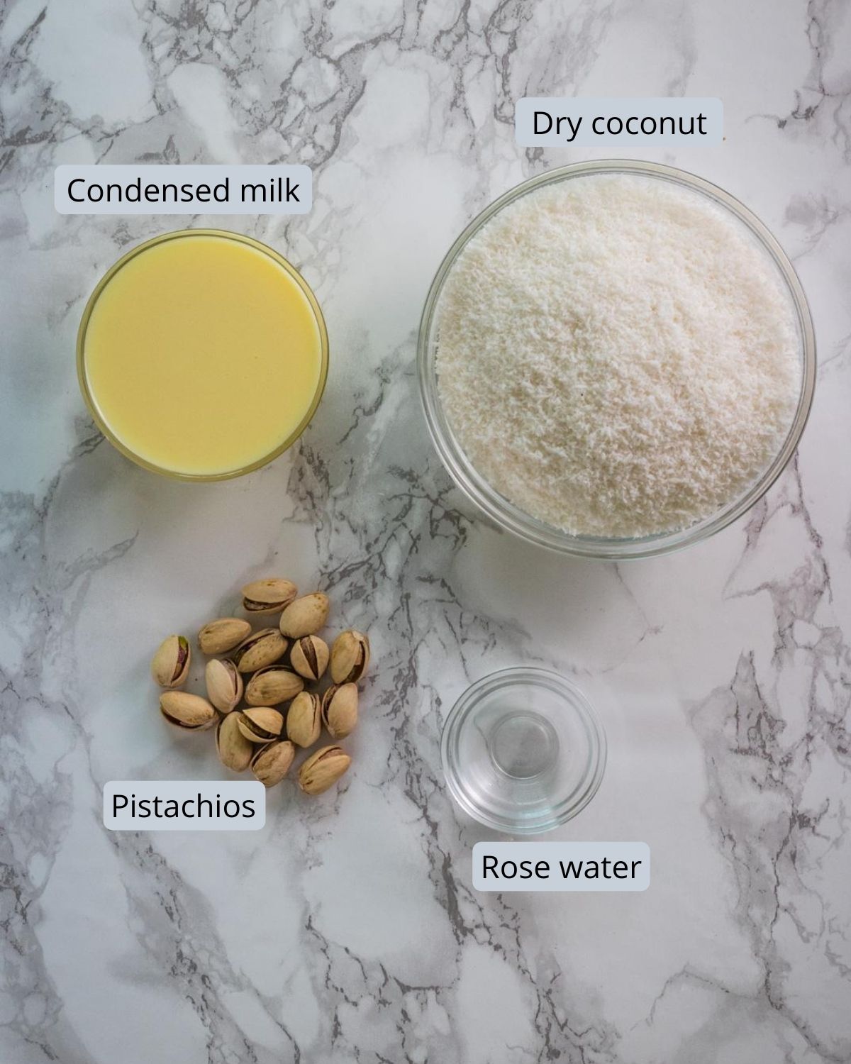 ingredients used in coconut burfi includes dry coconut, condensed milk, rose water, pista