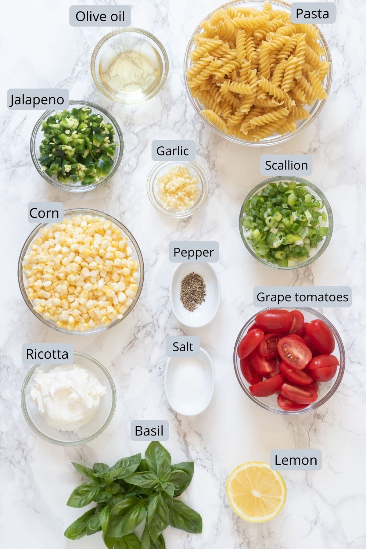 Corn pasta ingredients in bowls and spoons with label.