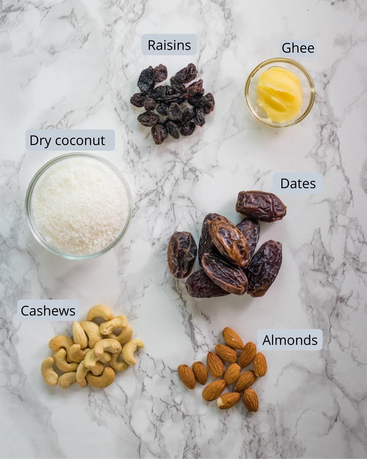 image of ingredients used in dry fruits modak. Shows dates, almonds, cashews, raisins, coconut and ghee