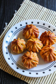 Image of fried modaks on plate with bamboo mat underneath.