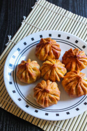 Image of fried modaks on plate with bamboo mat underneath.