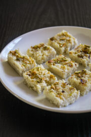 9 pieces of kalakand sweet on a white plate