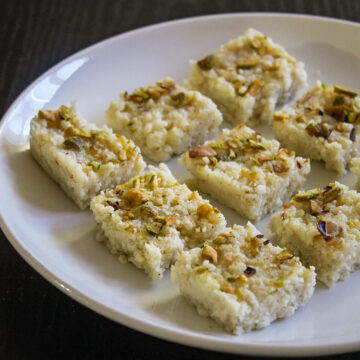 9 pieces of kalakand sweet on a white plate