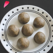 6 bajra ladoo on a plate with rose petals on side as a garnish