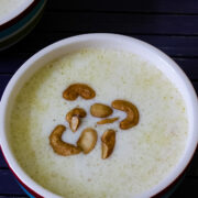 Close up image of paal payasam in a bowl with garnish of fried cashews.