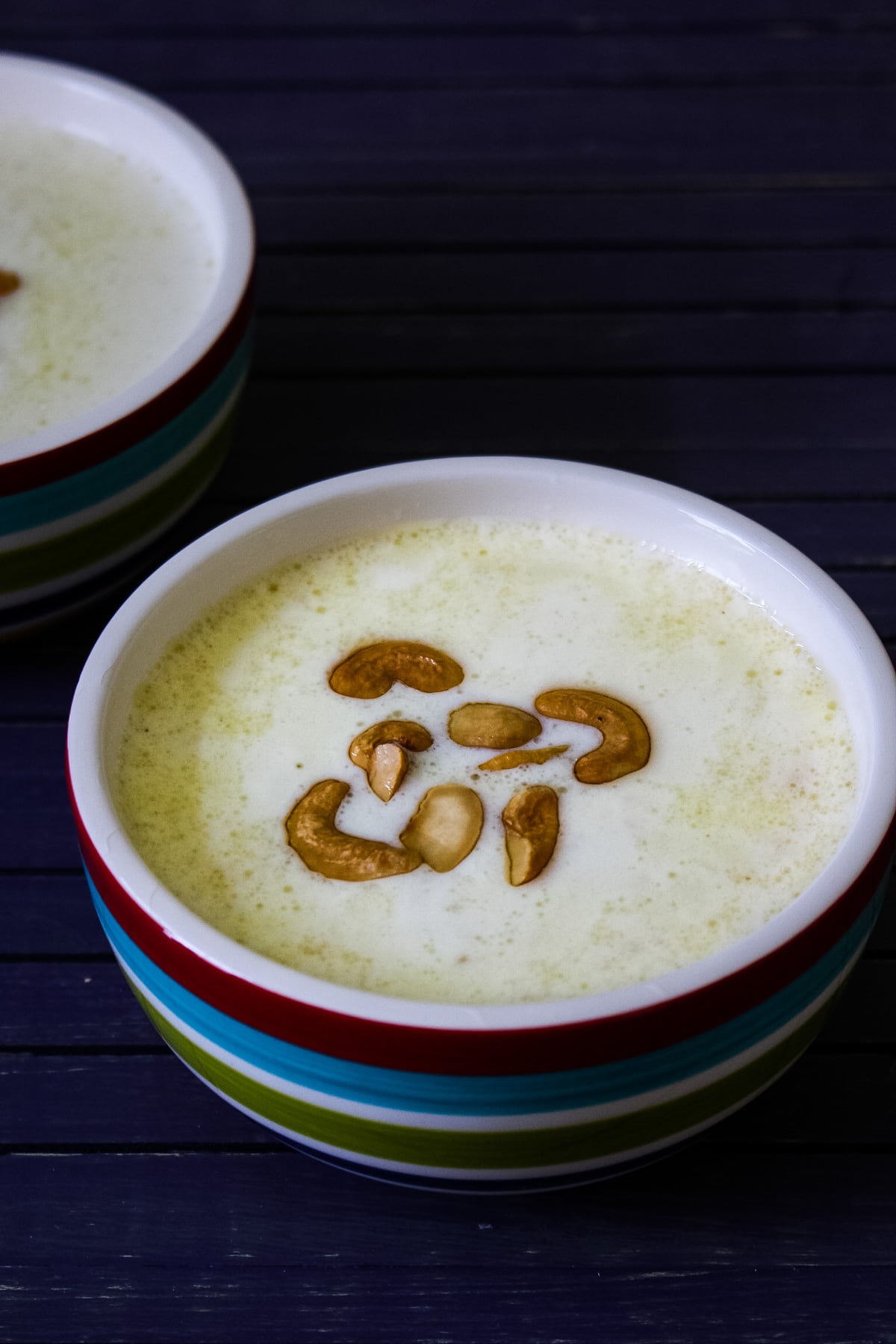 Paal payasam served in a bowl with garnish of ghee-fried cashew nuts.