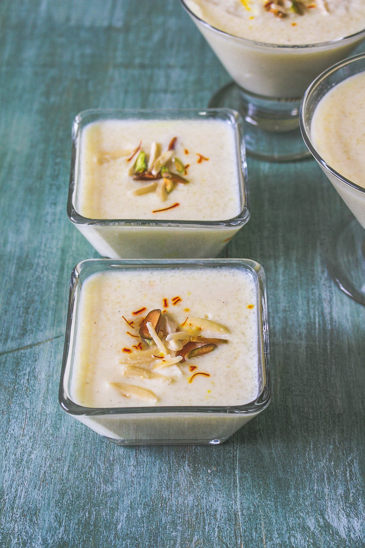 phirni in individual serving bowl garnish with sliced nuts and saffron.