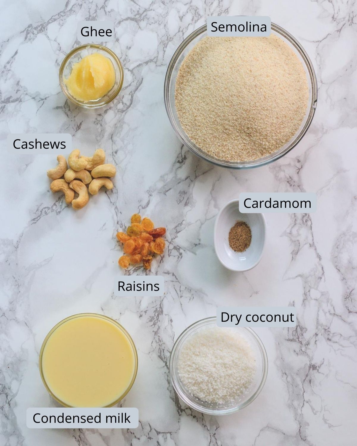 image of ingredients used in rava ladoo recipe. Includes semolina, ghee, cashews, raisins, cardamom, coconut, condensed milk