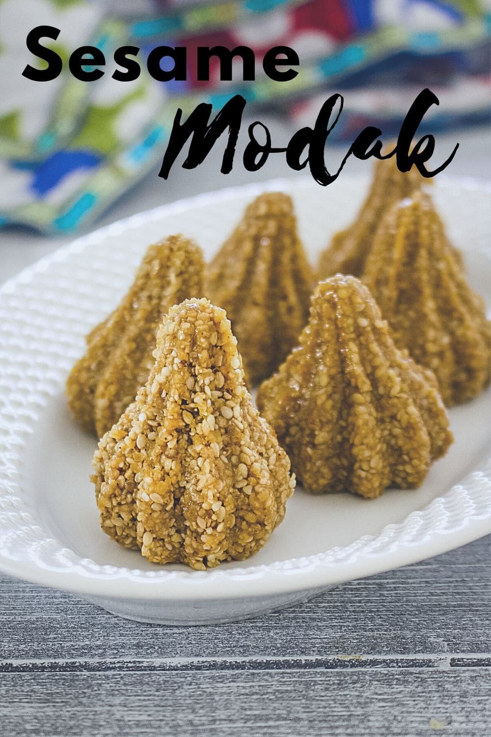 5 sesame seeds modak in an oval plate with text 'sesame modak' for piterest