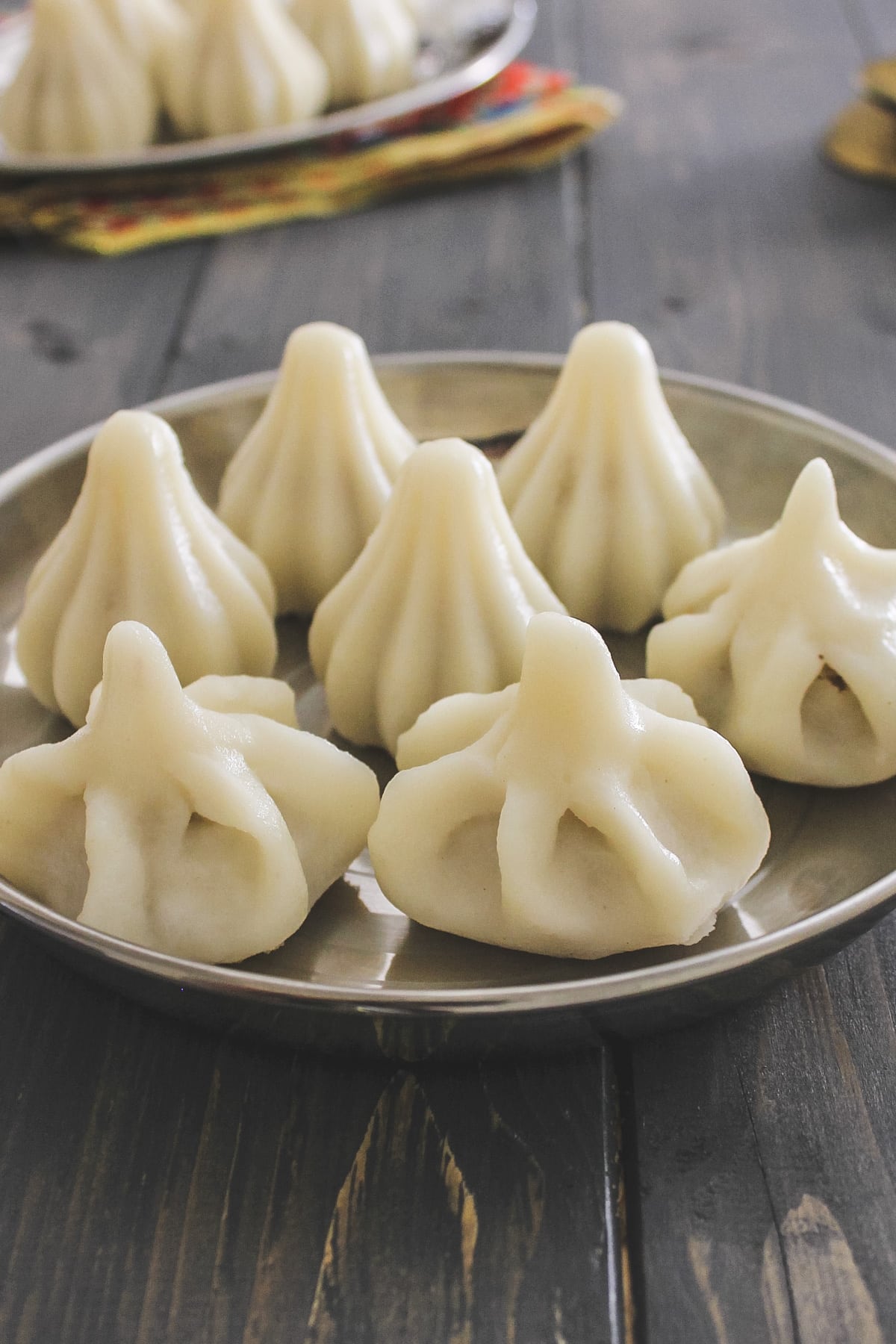 3 handmade modaks & 4 mould shaped modak on steel plate