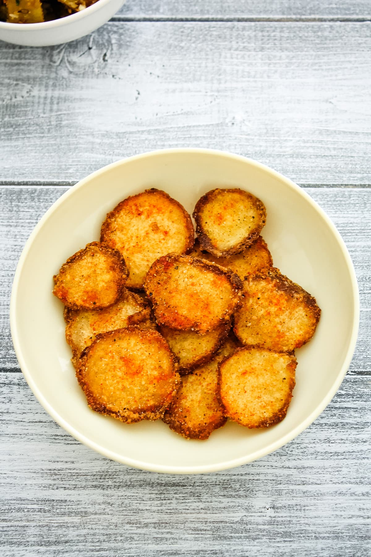 arbi chips in a plate with wood background