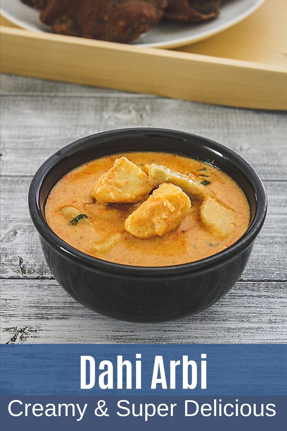 dahi arbi in a bowl with text on the image for pinterest