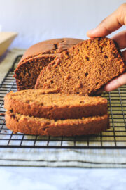 pumpkin bread on a rack lifting one slice ready to eat
