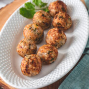 Sabudana vada in an oval plate with garnish of cilantro on a wooden board.