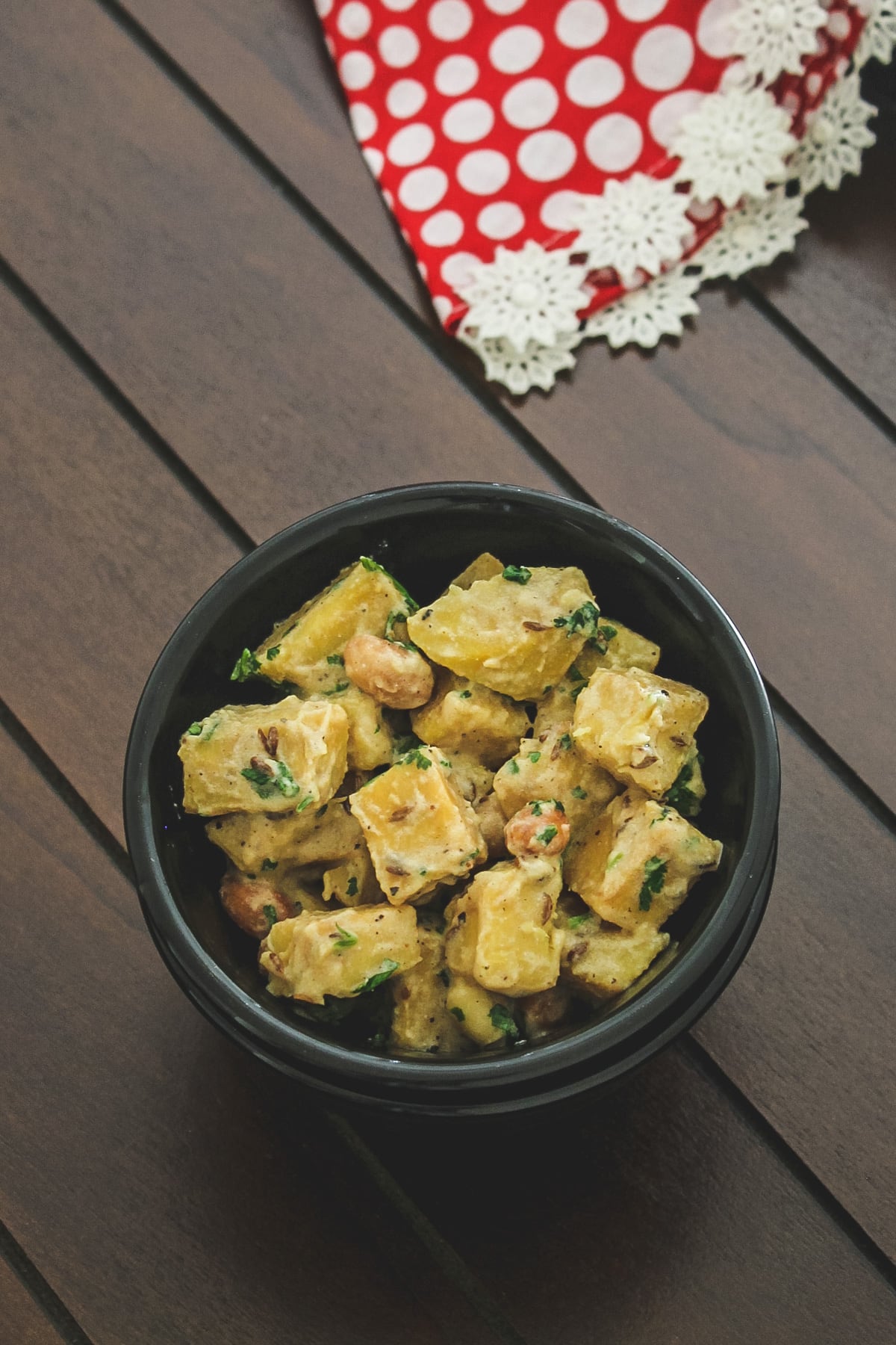 suran sabji in a black bowl with red polka dot napkin in the back