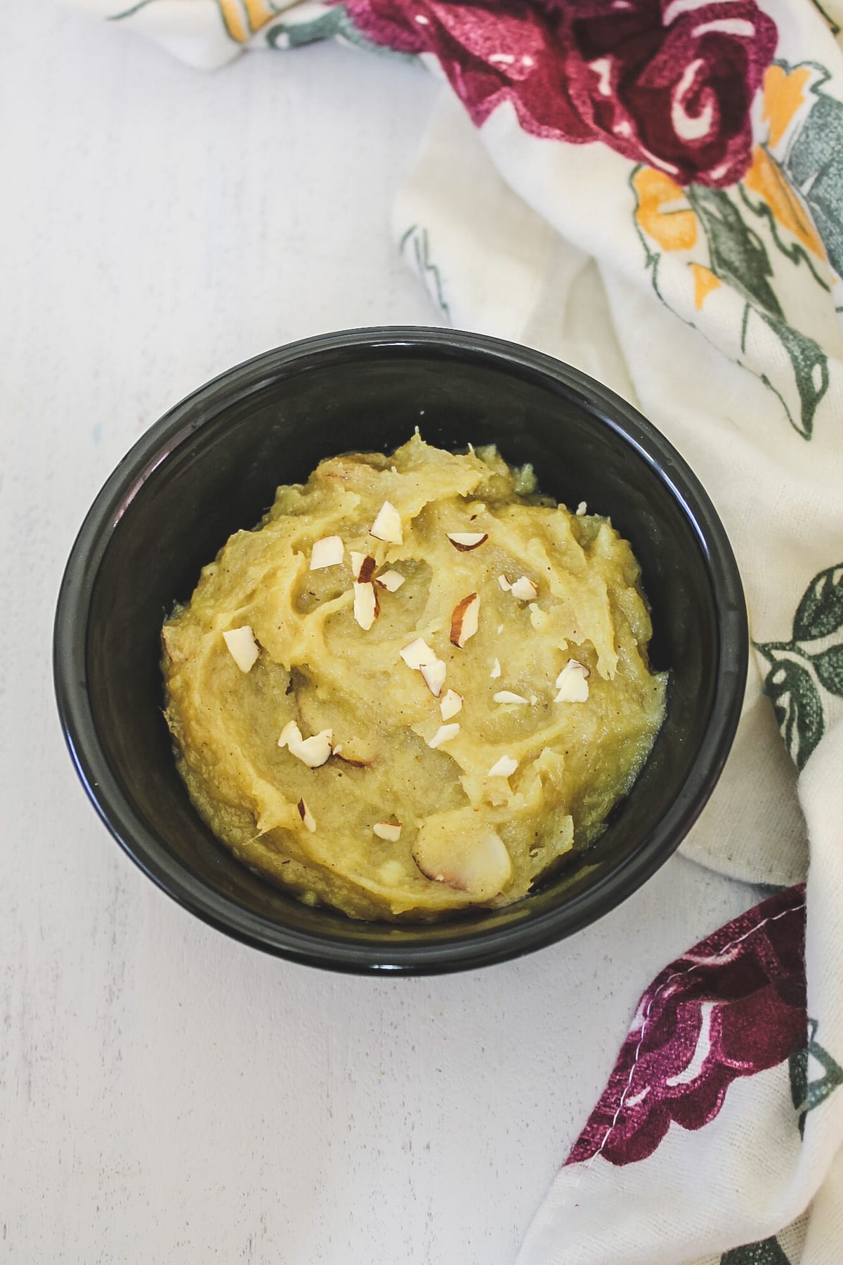 sweet potato halwa in a bowl garnished with almonds with napkin on side