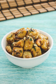 Sweet potato sabzi in a white bowl with blue background