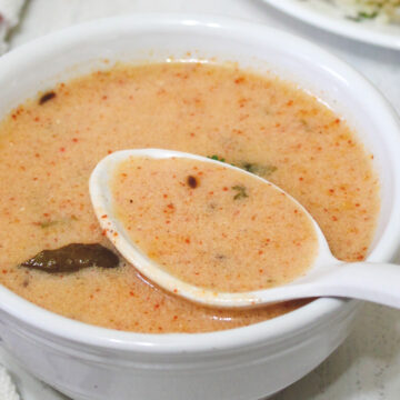 vrat ki kadhi in a bowl, a spoonful of taken from the bowl ready to eat