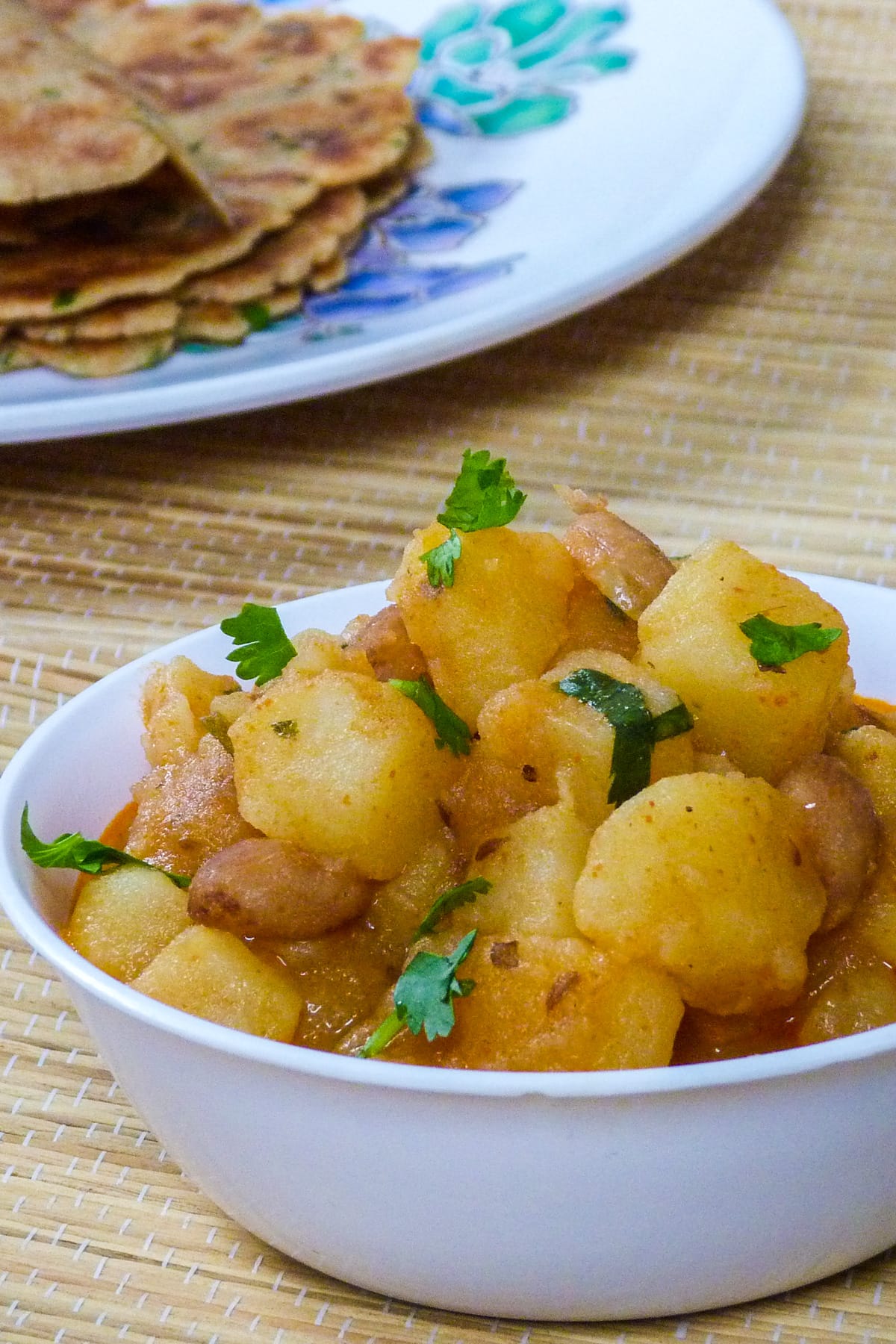 Vrat ke aloo in a white bowl with paratha seved in the back