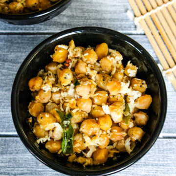 Chickpea sundal in 2 black bowls.