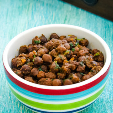 Dry chana in a bowl with wooden tray in the back,