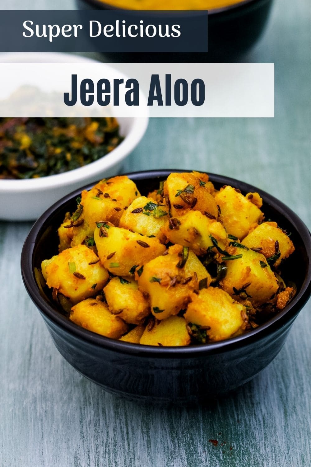 jeera aloo in a black bowl with text on the image for pinterest