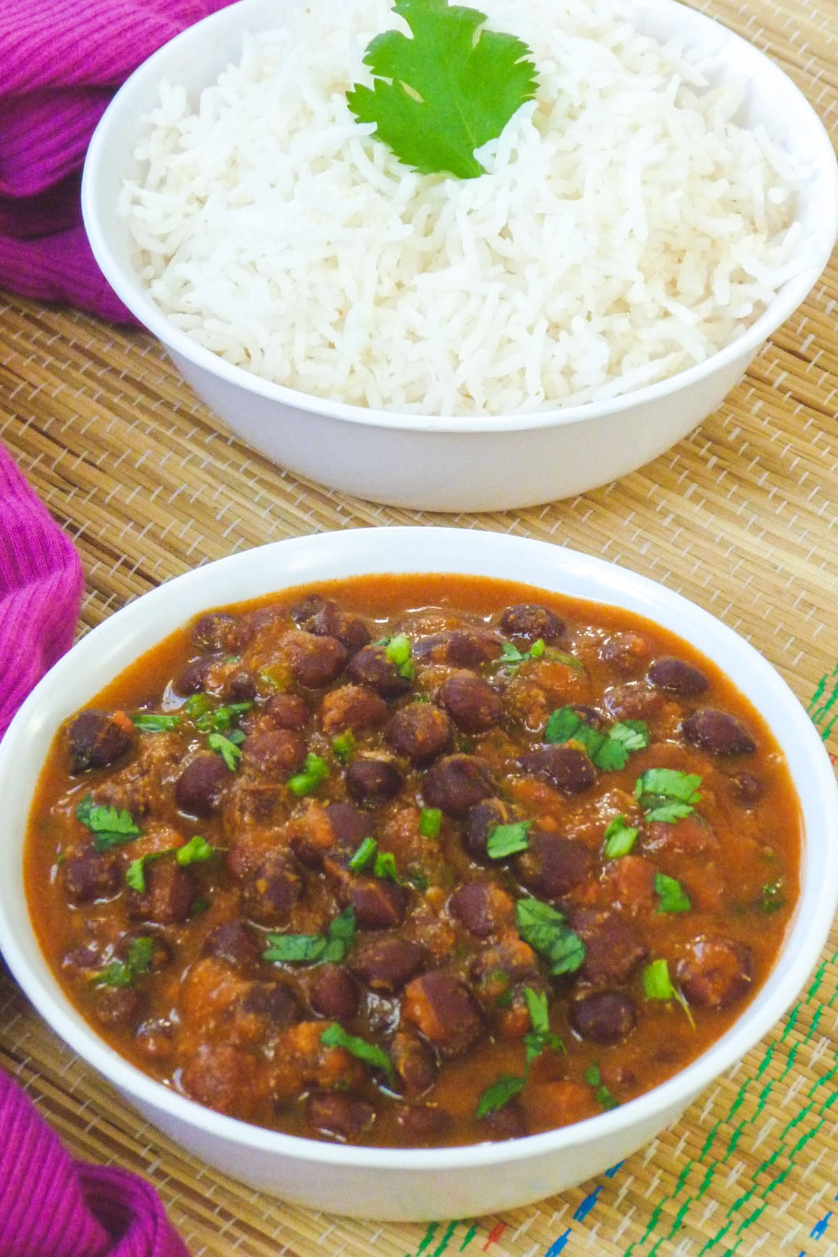 Black chickpea curry with garnish of cilantro served with rice.