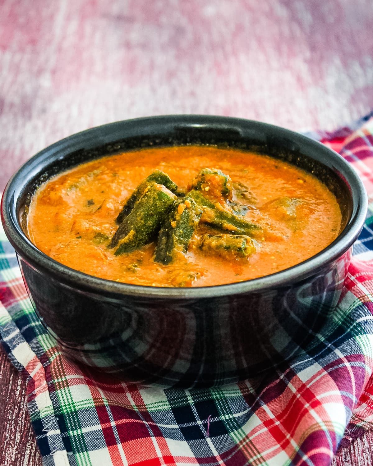 Bhindi curry in a bowl with napkin underneath the bowl.