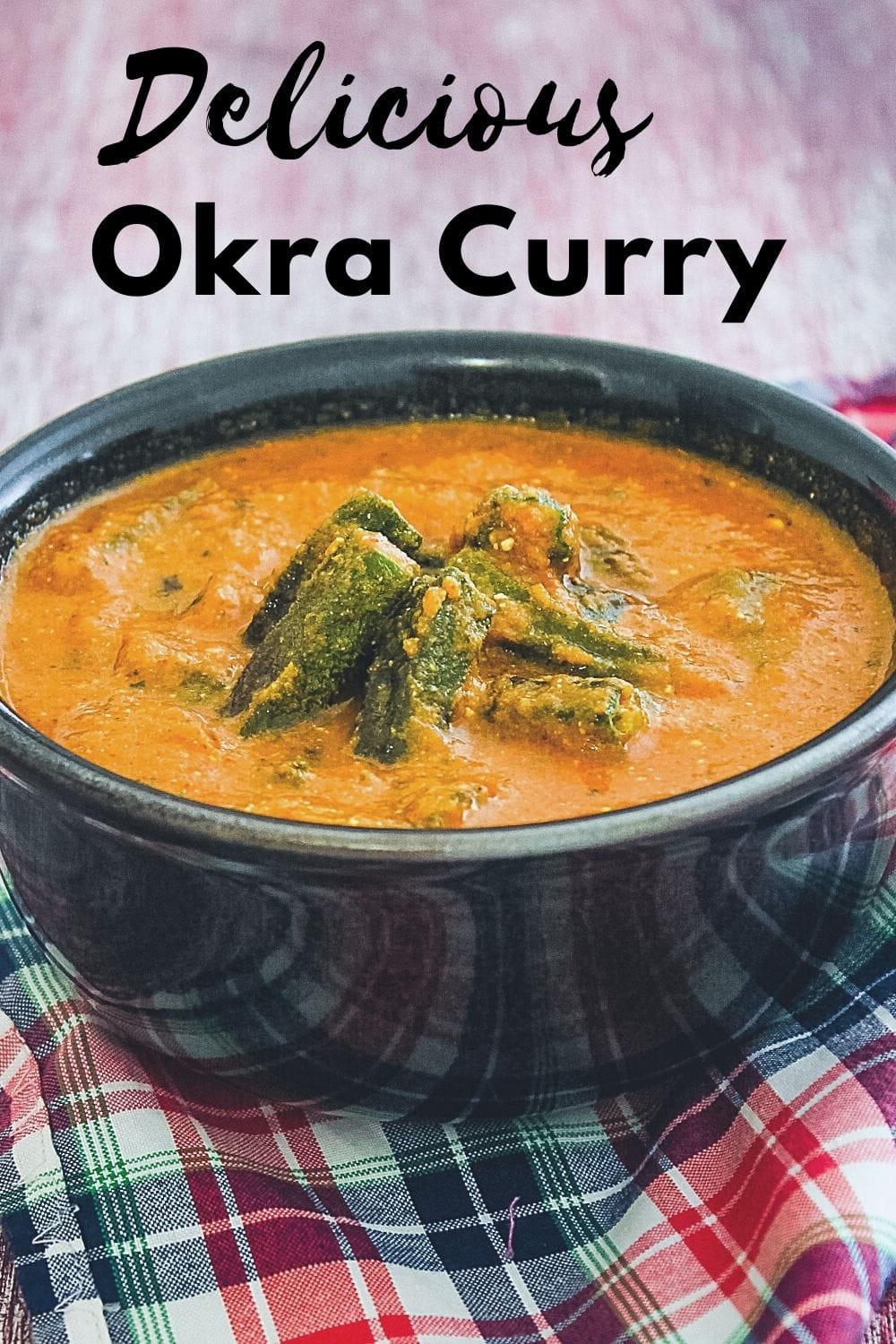 Bhindi curry in a bowl with napkin underneath with text on the image for pinterest