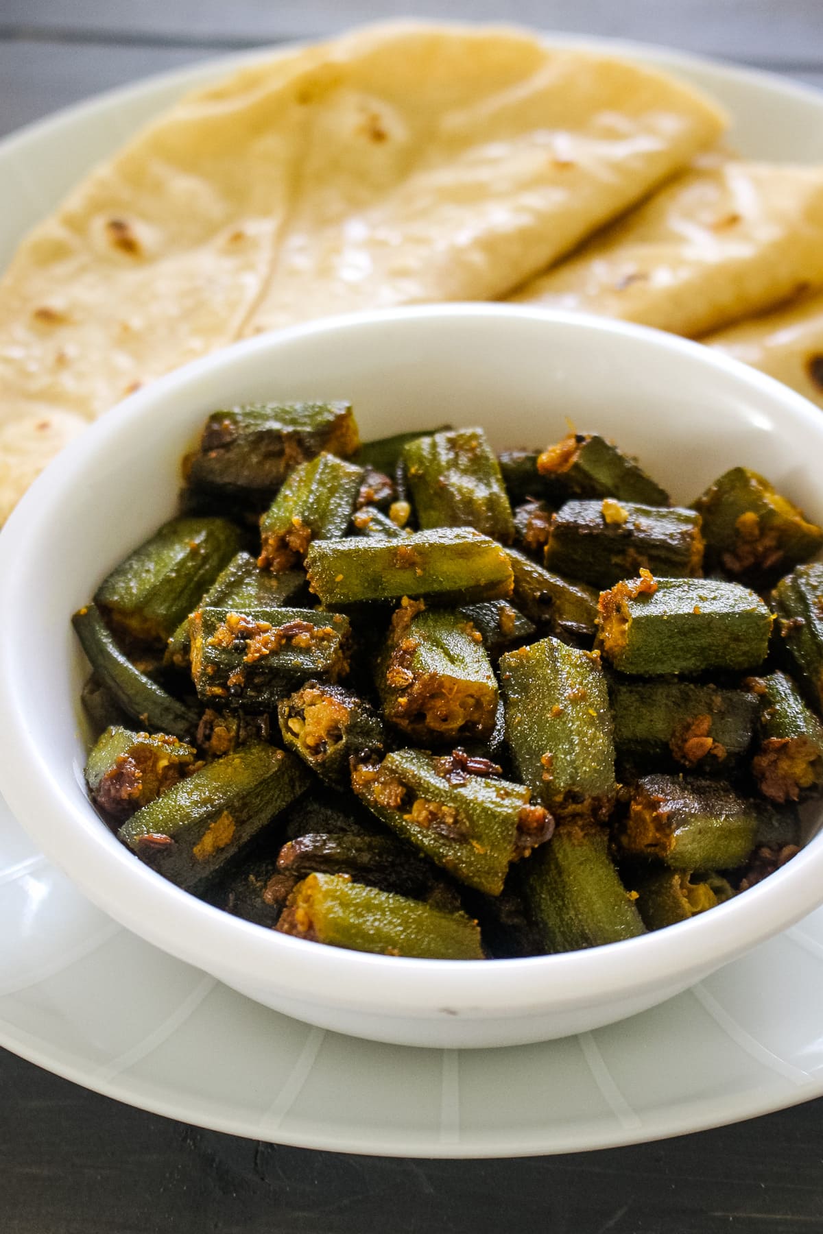 Close up of achari bhindi served with roti.