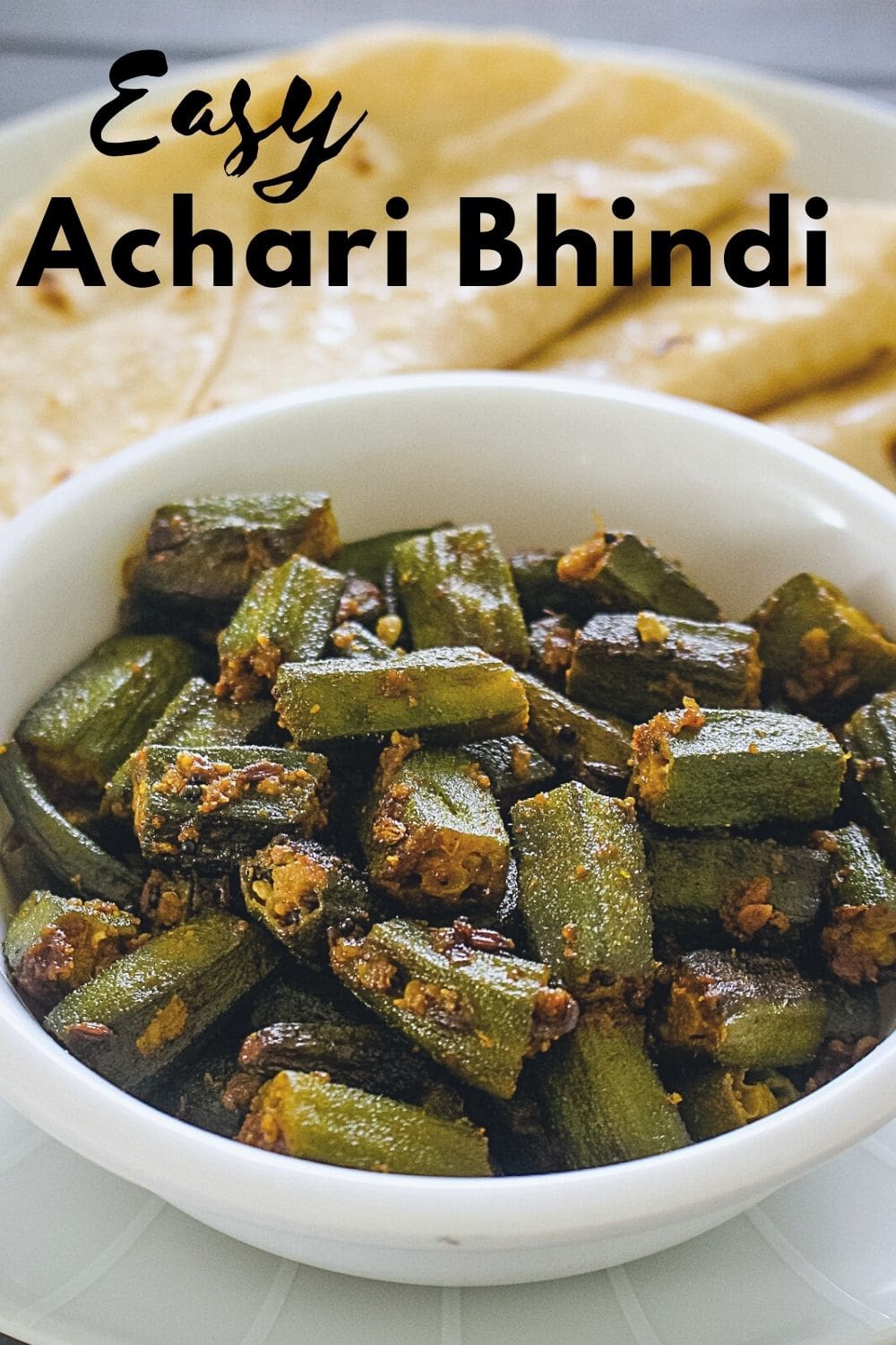 Achari bhindi served with 3 roti with text on the image.