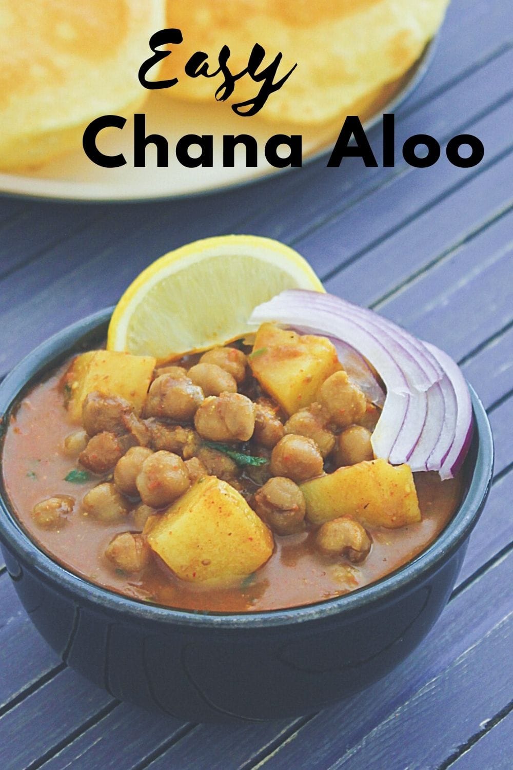 Aloo chana served in a bowl with sliced onion and lemon wedge with text on the image.