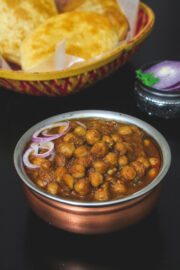 Close up of chole masala garnished with onion rings.