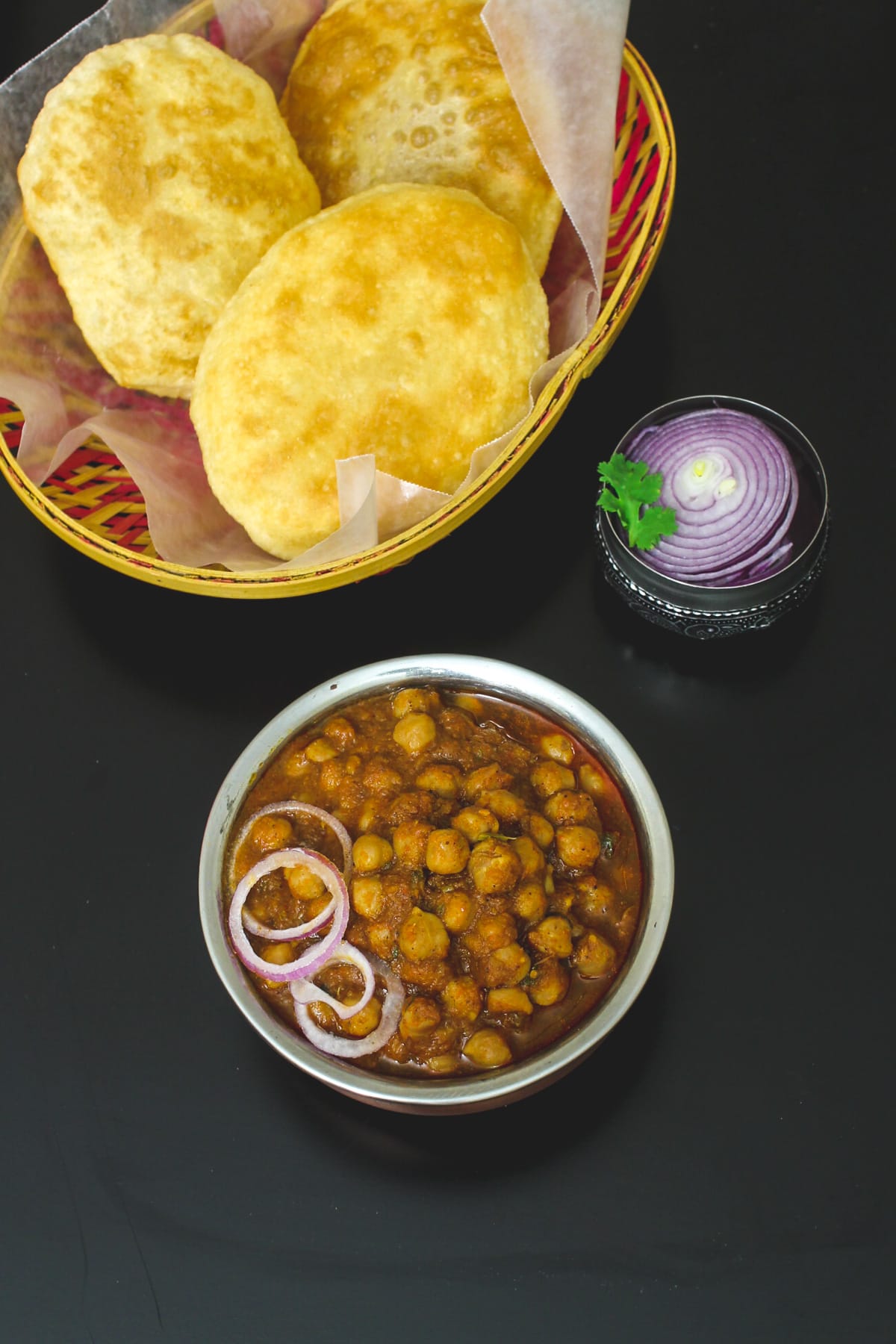 Punjabi chole served with onion and bhatura.