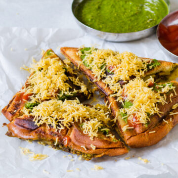 4 slices of bombay masala toast sandwich served with chutney and ketchup.