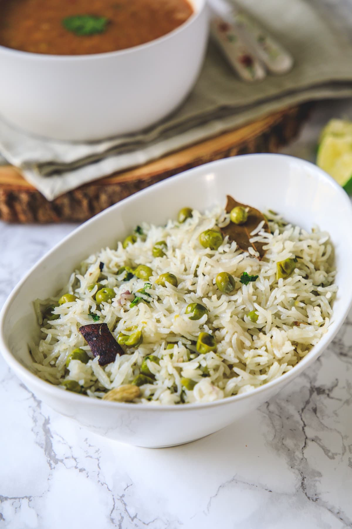 Peas pulao in a bowl with side of dal.