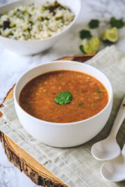 toor dal in a bowl with cilantro served with pulao.