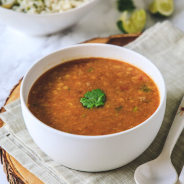 toor dal in a bowl with cilantro served with pulao.