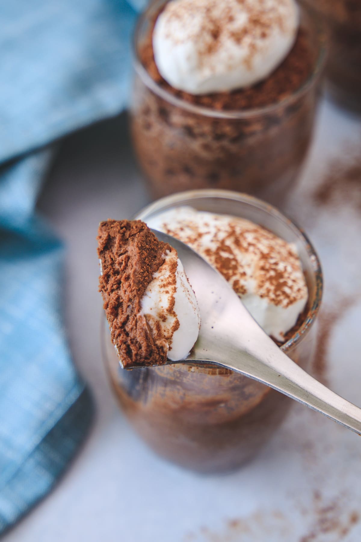 A spoonful of chocolate mousse taken from a serving bowl.