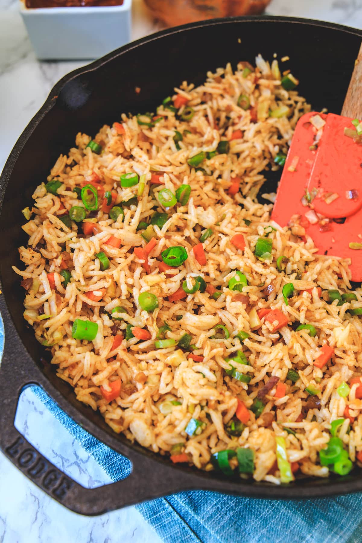 schezwan fried rice in a cast iron pan with spatula.