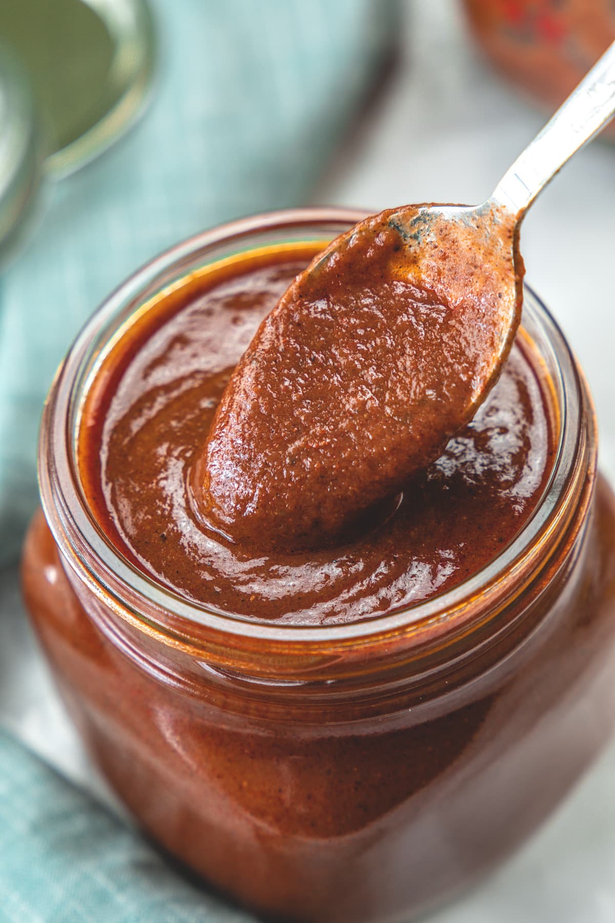 Spoonful of enchilada sauce taking from the jar.